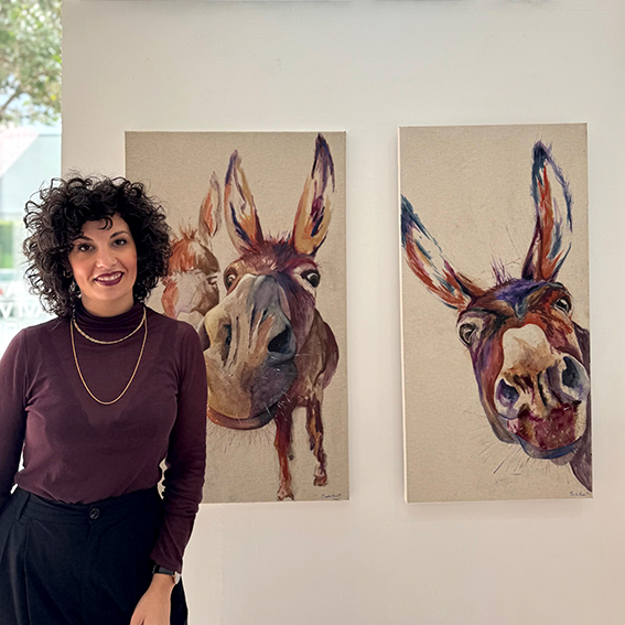 Sandra Nadal frente a sus cuadros en una exposición colaborativa